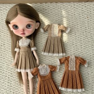 Overview of four vintage-inspired doll dresses in pumpkin and khaki brown, with pintuck bib and lace-front designs.
